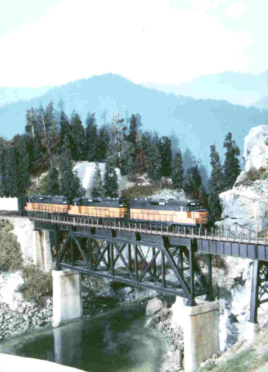 Steve Depolo's Milwaukee Road - layout. Photo of a bridge, a tall steel trestle crossing a gorge, atop concrete piers and abutments by C. C. Crow. This C. C. Crow photo appeared on cover of Mainline Modeler magazine.
